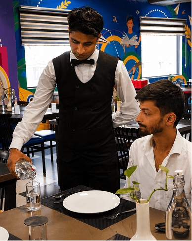 Waiter serving a guest in a training restaurant