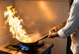Chef flambéing food in the kitchen