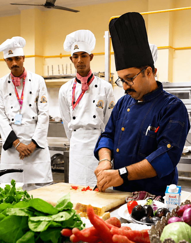 Chef instructor demonstrating culinary techniques to students