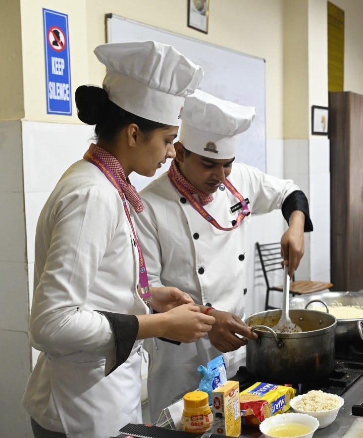 Chef stir-frying vegetables in a professional training kitchen